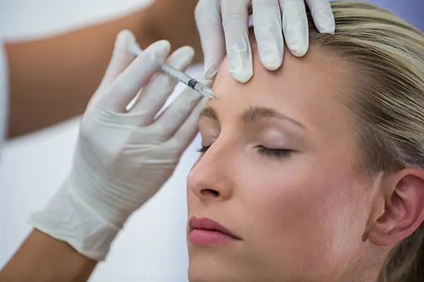 Female patient receiving neuromodulator on face